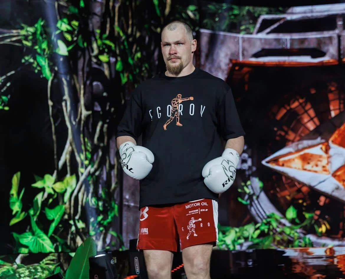 Алексей Егоров в фирменной футболке и боксёрских перчатках